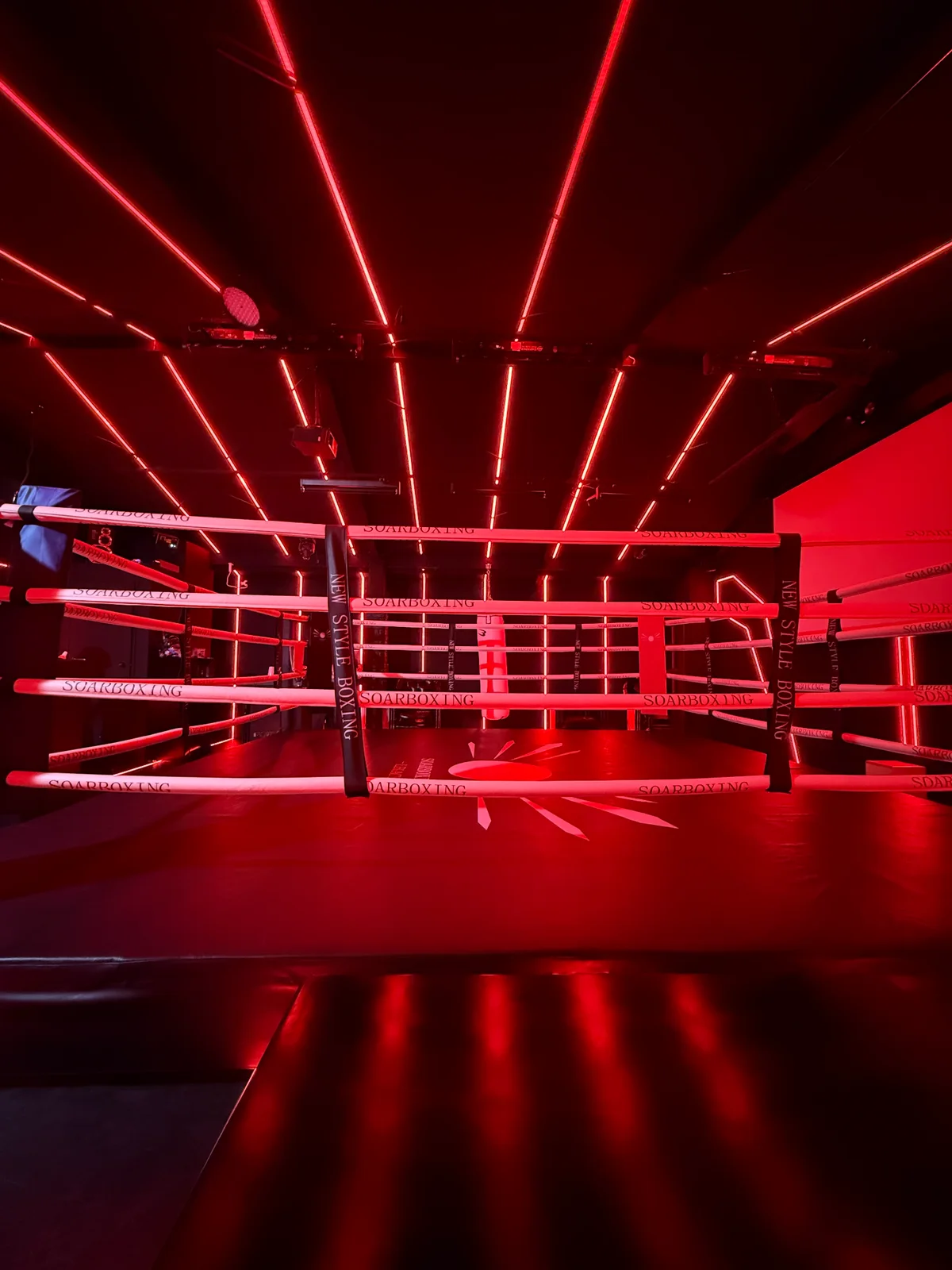 赤いLED照明で演出されたSOARBOXING LEGACYのボクシングリング
